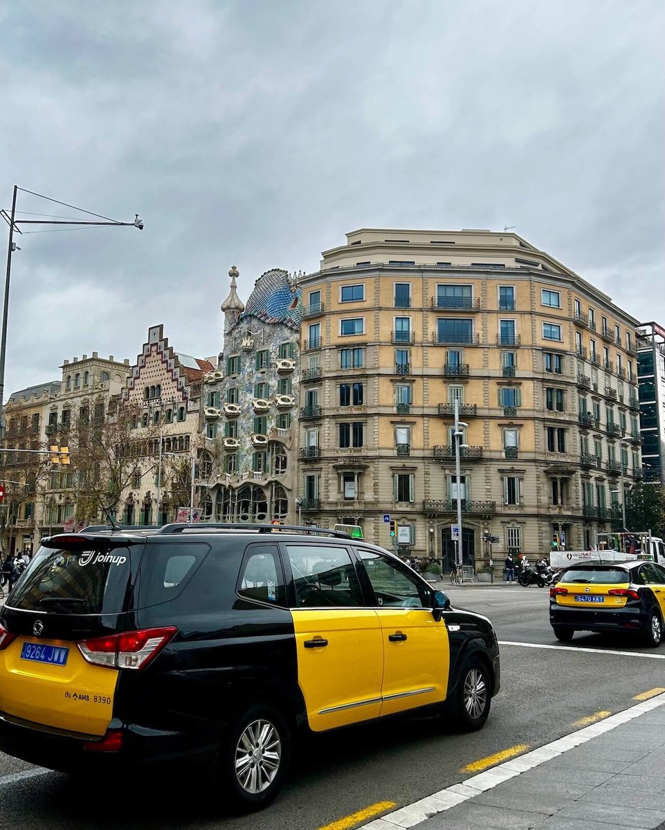 Black and yellow taxis in front of the the Gaudi building in Barcelona, Spain